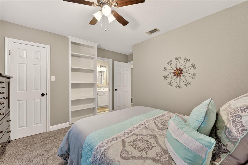 703 Gibraltar Lane Lorena, TX 76655 - Photo 13 of 39 a bedroom with a large bed and a chandelier
