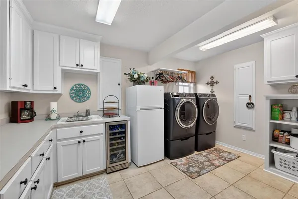 a kitchen with kitchen island granite countertop a sink a stove a refrigerator and cabinets