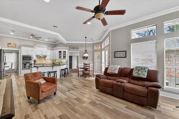 a living room with furniture kitchen view and a window