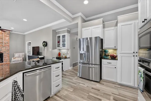 a kitchen with white cabinets and stainless steel appliances