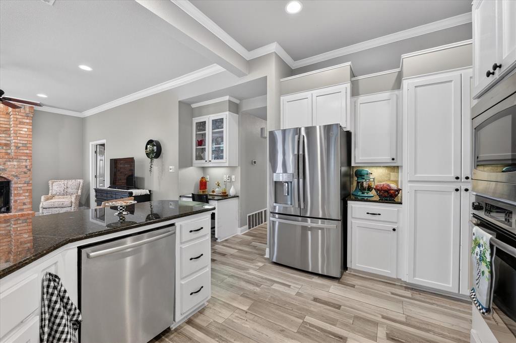 703 Gibraltar Lane Lorena, TX 76655 - Photo 29 of 39 a kitchen with white cabinets and stainless steel appliances