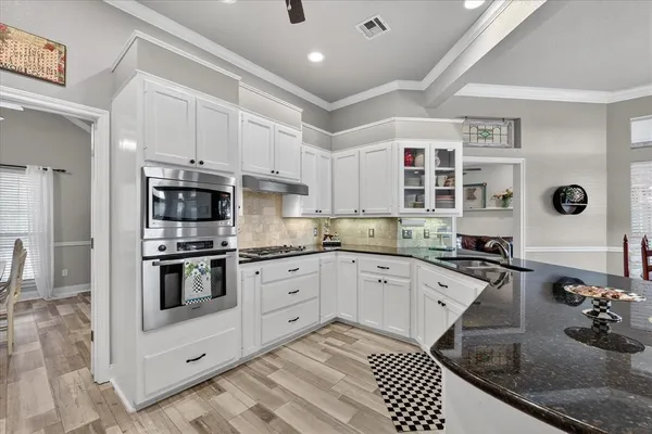 a kitchen with stainless steel appliances granite countertop a sink and cabinets