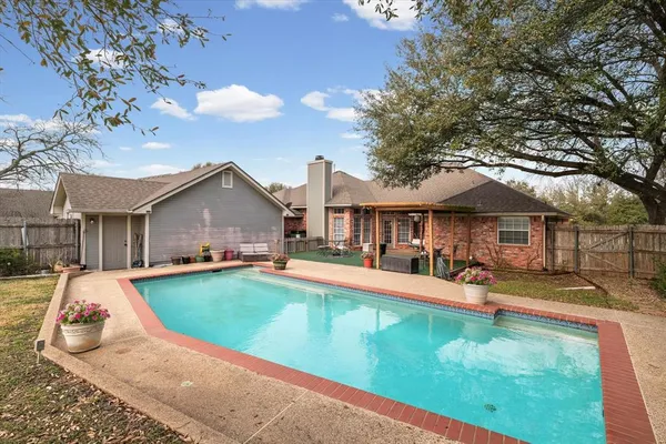 swimming pool view with a seating space and a garden view