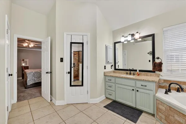 a spacious bathroom with a double vanity sink a mirror and a