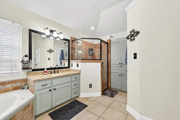 a spacious bathroom with a double vanity sink a mirror and a shower
