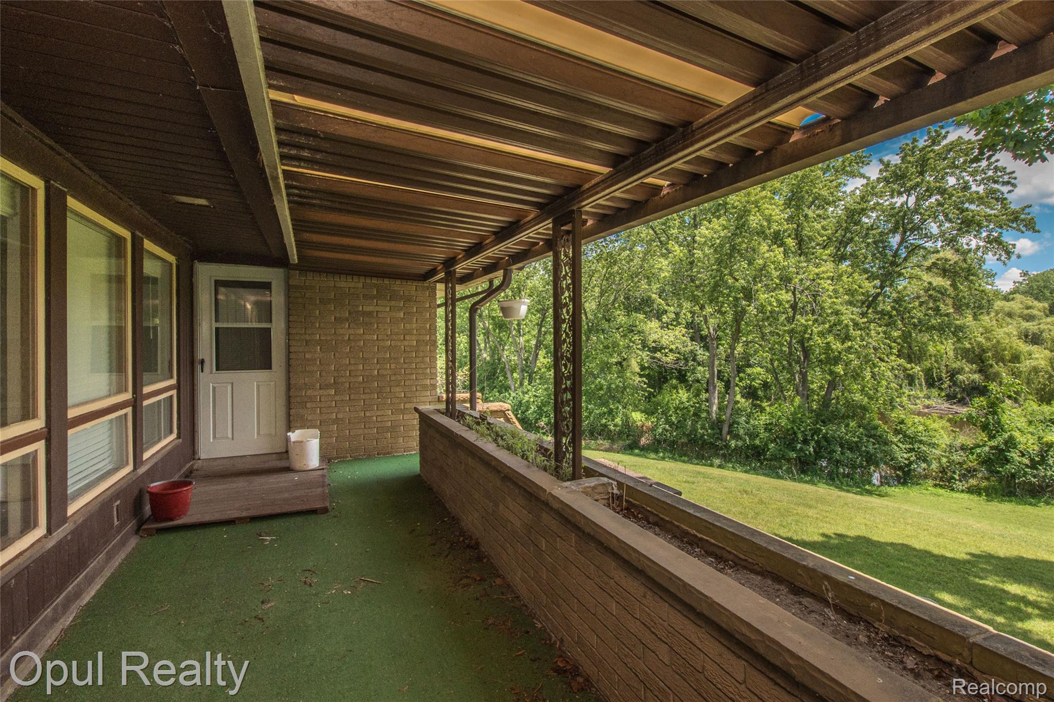 6455 Norham Road Bloomfield Hills, MI 48301 - Photo 12 of 93 Covered porch featuring a wood-panel ceiling and an exposed brick facade