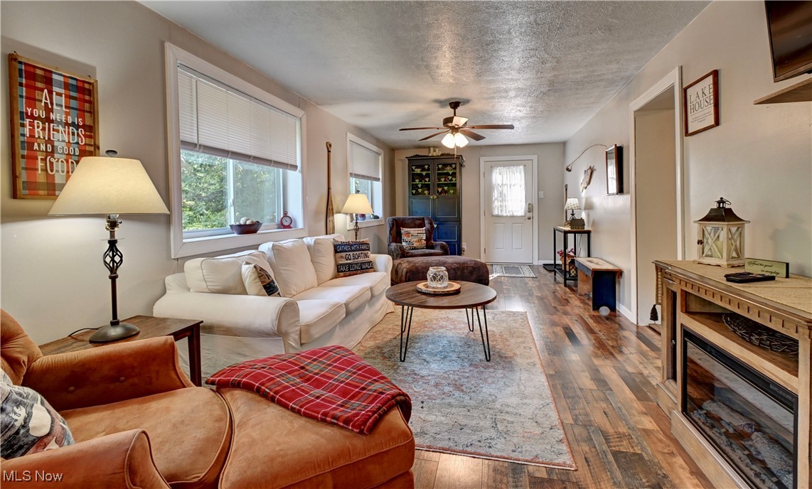 2227 Elk Road Southwest Carrollton, OH 44615 - Photo 22 of 40 Living area featuring healthy amount of natural light, hardwood / wood-style flooring, a ceiling fan, and a textured ceiling
