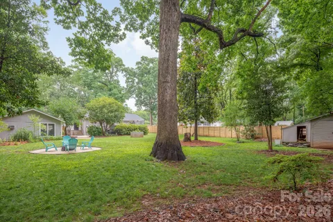 a view of a house with a big yard and large trees