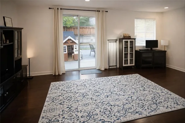 a living room with stainless steel appliances kitchen island granite countertop a refrigerator and a sink