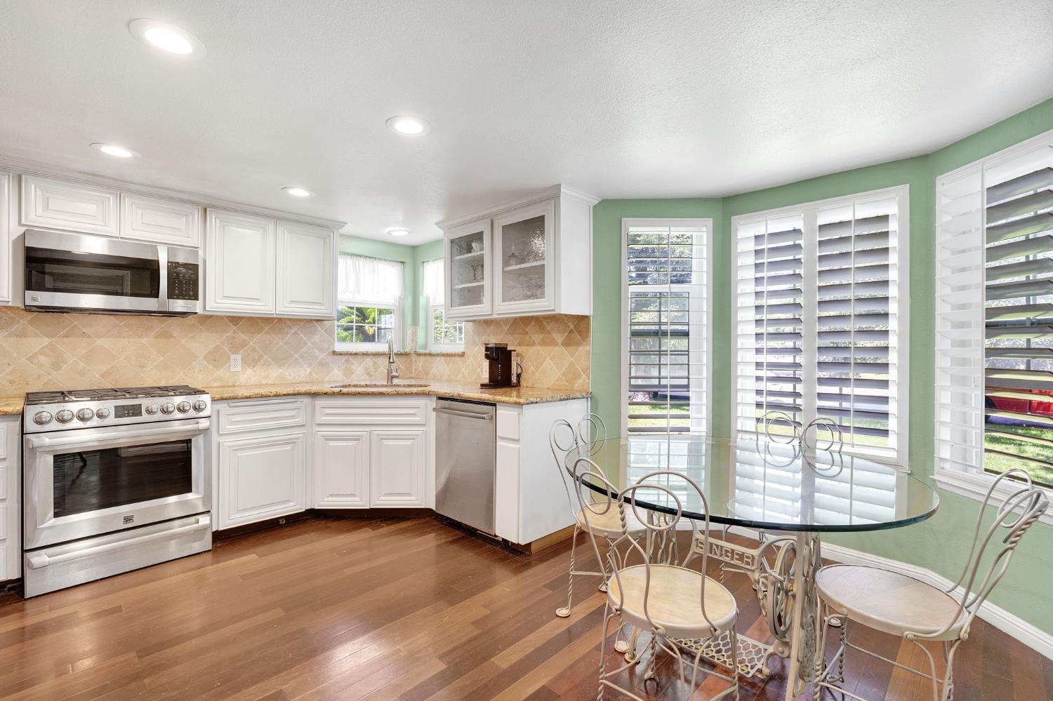 200 Lyons Street Madera, CA 93638 - Photo 16 of 32 a kitchen with granite countertop a stove a sink and a microwave