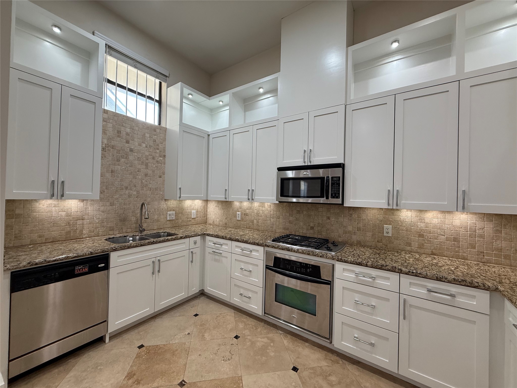 1608 Patterson Street, Unit A Houston, TX 77007 - Photo 5 of 20 a kitchen with granite countertop a sink stainless steel appliances and cabinets