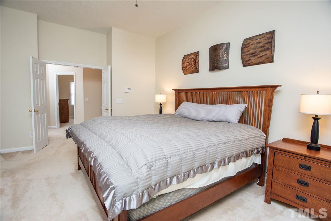 2921 Englefield Drive Raleigh, NC 27615 - Photo 14 of 27 a bedroom with a bed and a night stand