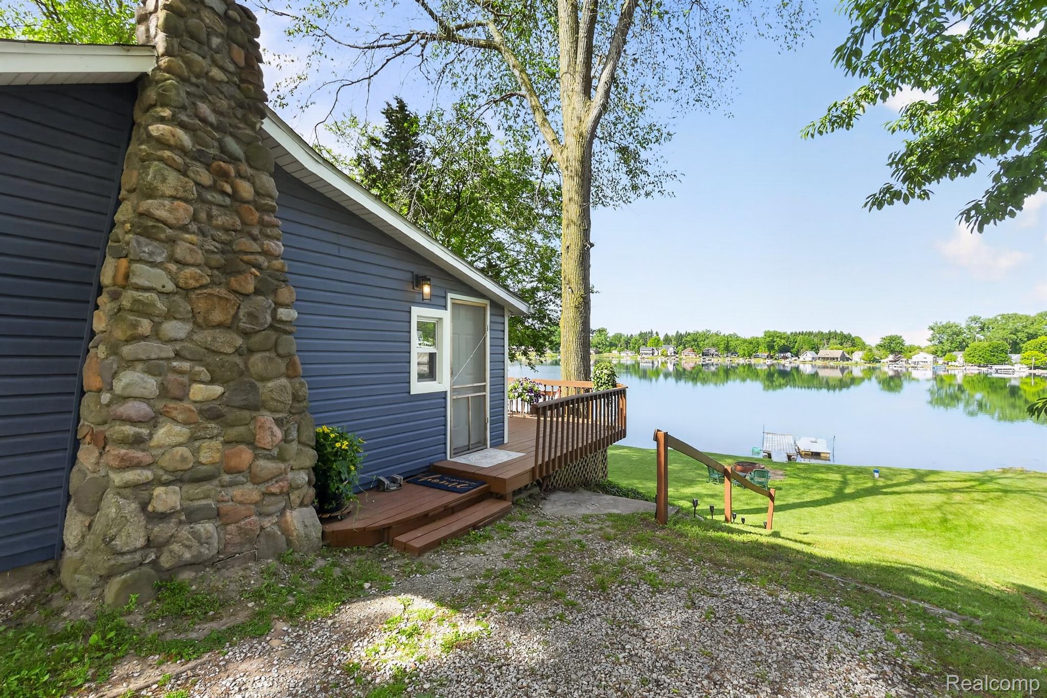 1717 Triangle Lake Road Howell, MI 48843 - Photo 4 of 58 Waterfront property featuring blue horizontal siding and a stone-clad chimney