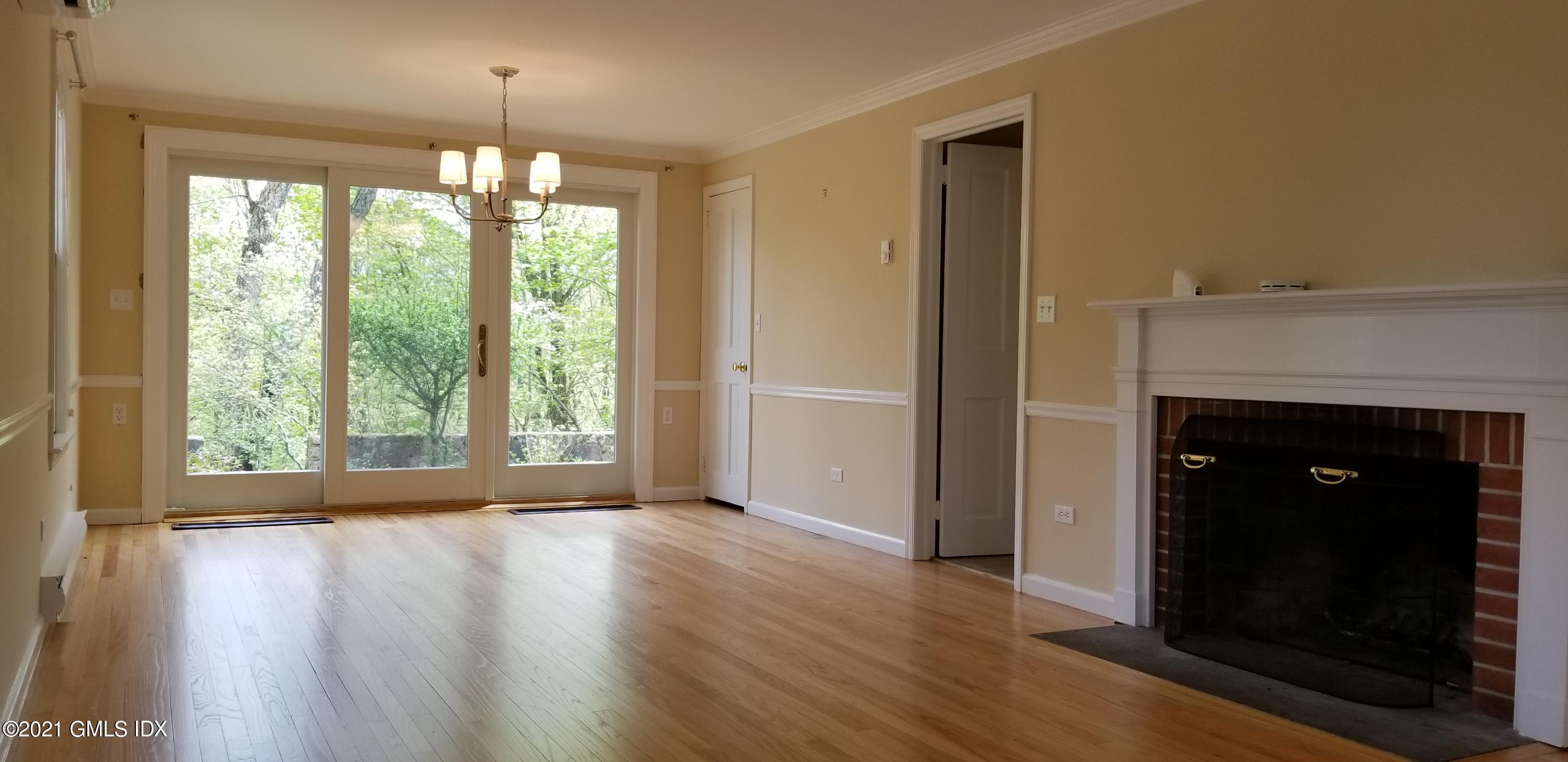 46 Ledge Brook Road Stamford, CT 06903 - Photo 5 of 23 a view of an empty room with wooden floor fireplace and a window