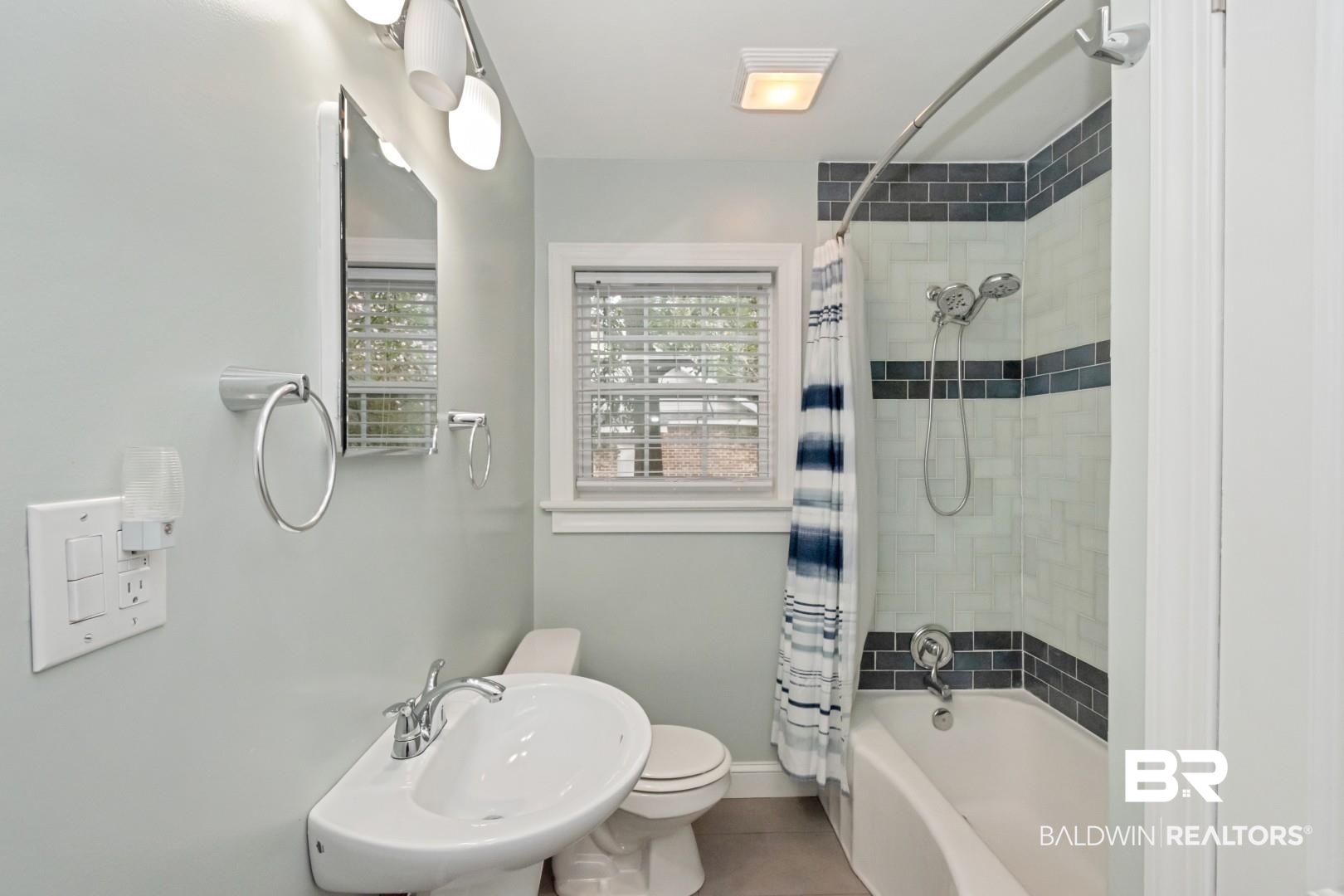 2157 Homewood Street Mobile, AL 36606 - Photo 26 of 36 Bathroom featuring baseboards, toilet, shower / tub combo with curtain, tile patterned flooring, and a sink