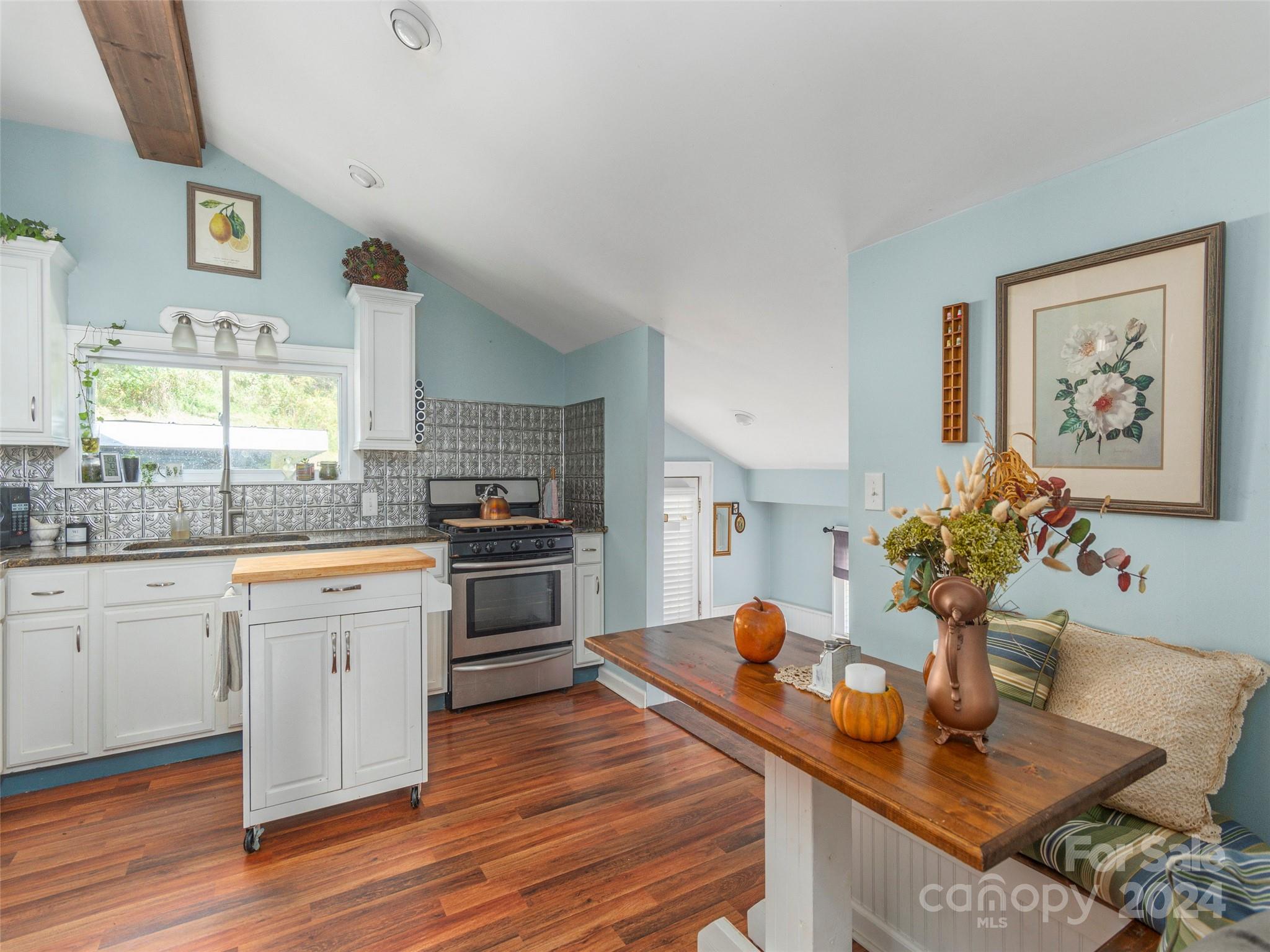 883 Price Town Road Clyde, NC 28721 - Photo 12 of 34 a kitchen with stainless steel appliances granite countertop a stove a sink dishwasher and a refrigerator with wooden floor