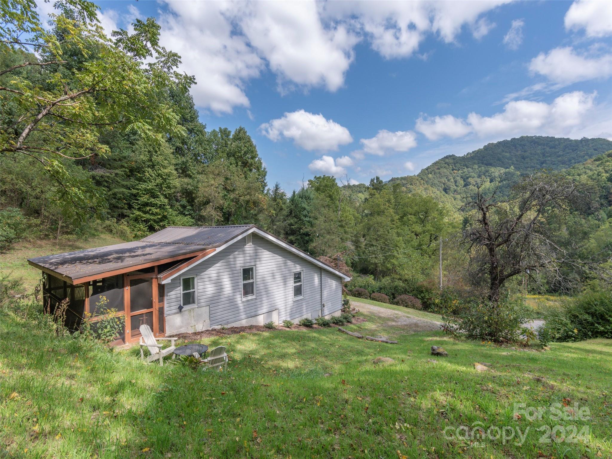 883 Price Town Road Clyde, NC 28721 - Photo 24 of 34 a backyard of a house with table and chairs