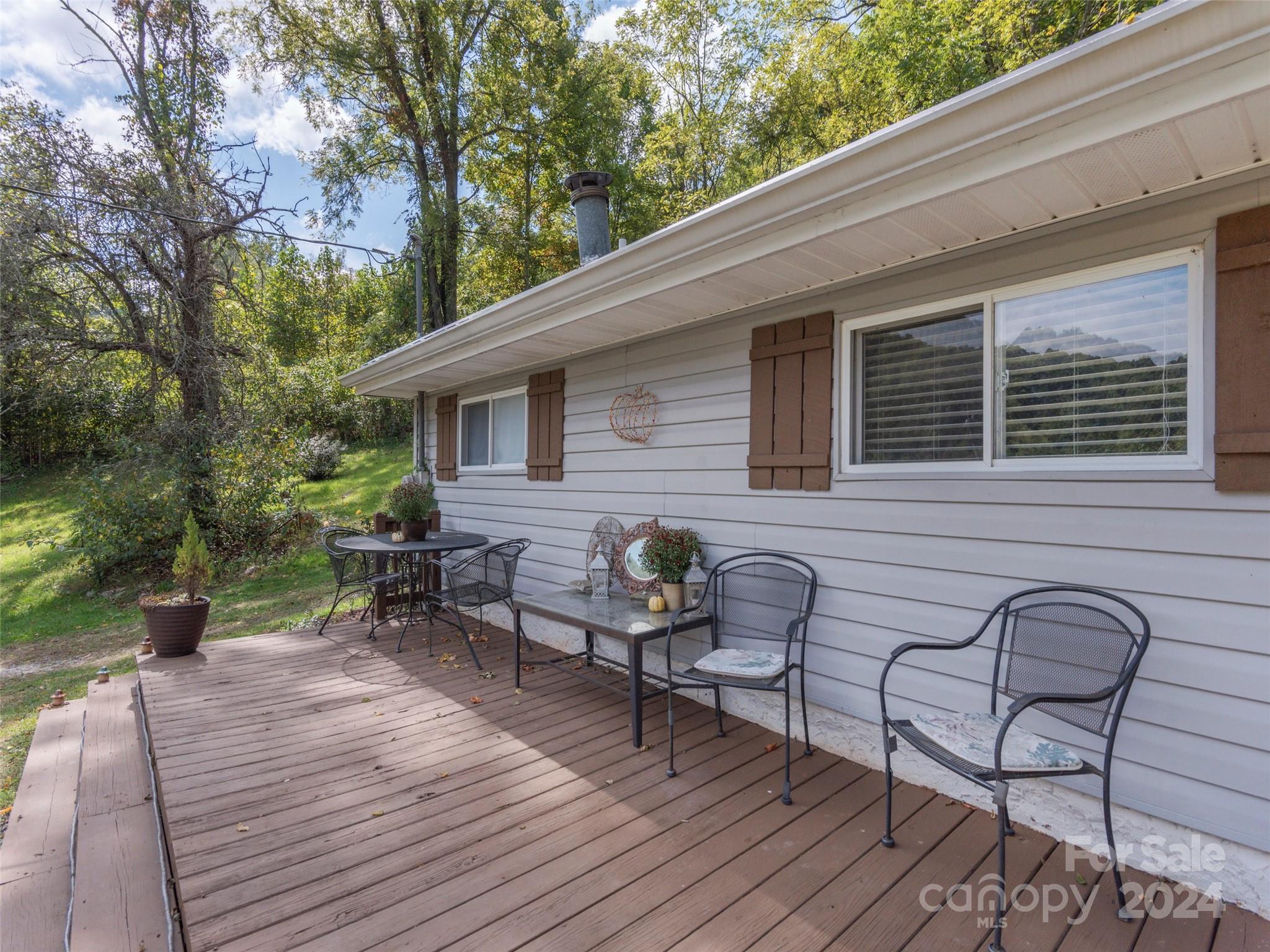 883 Price Town Road Clyde, NC 28721 - Photo 25 of 34 a backyard of a house with wooden floor yard and outdoor seating