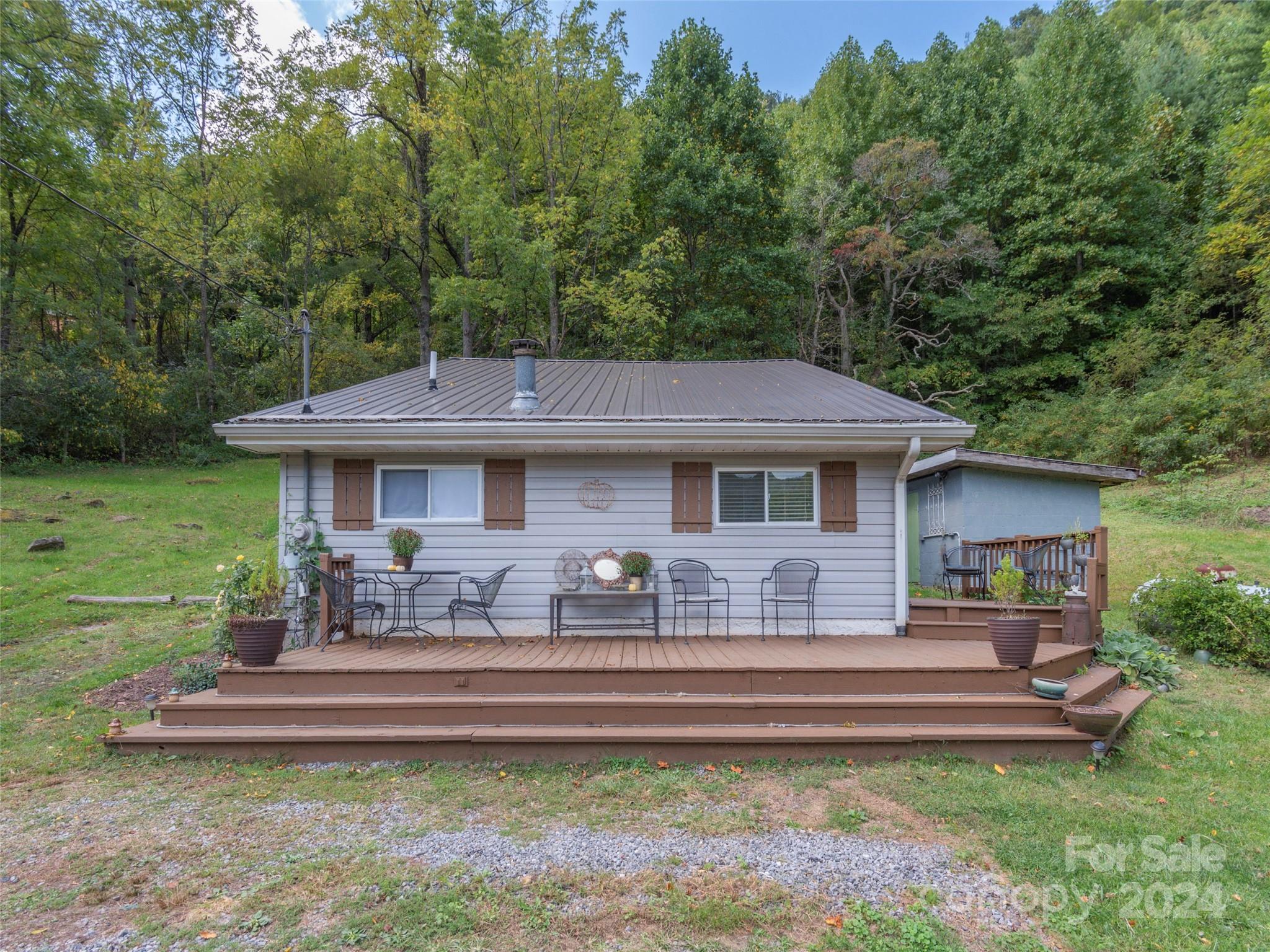 883 Price Town Road Clyde, NC 28721 - Photo 28 of 34 a front view of a house with a yard table and chairs