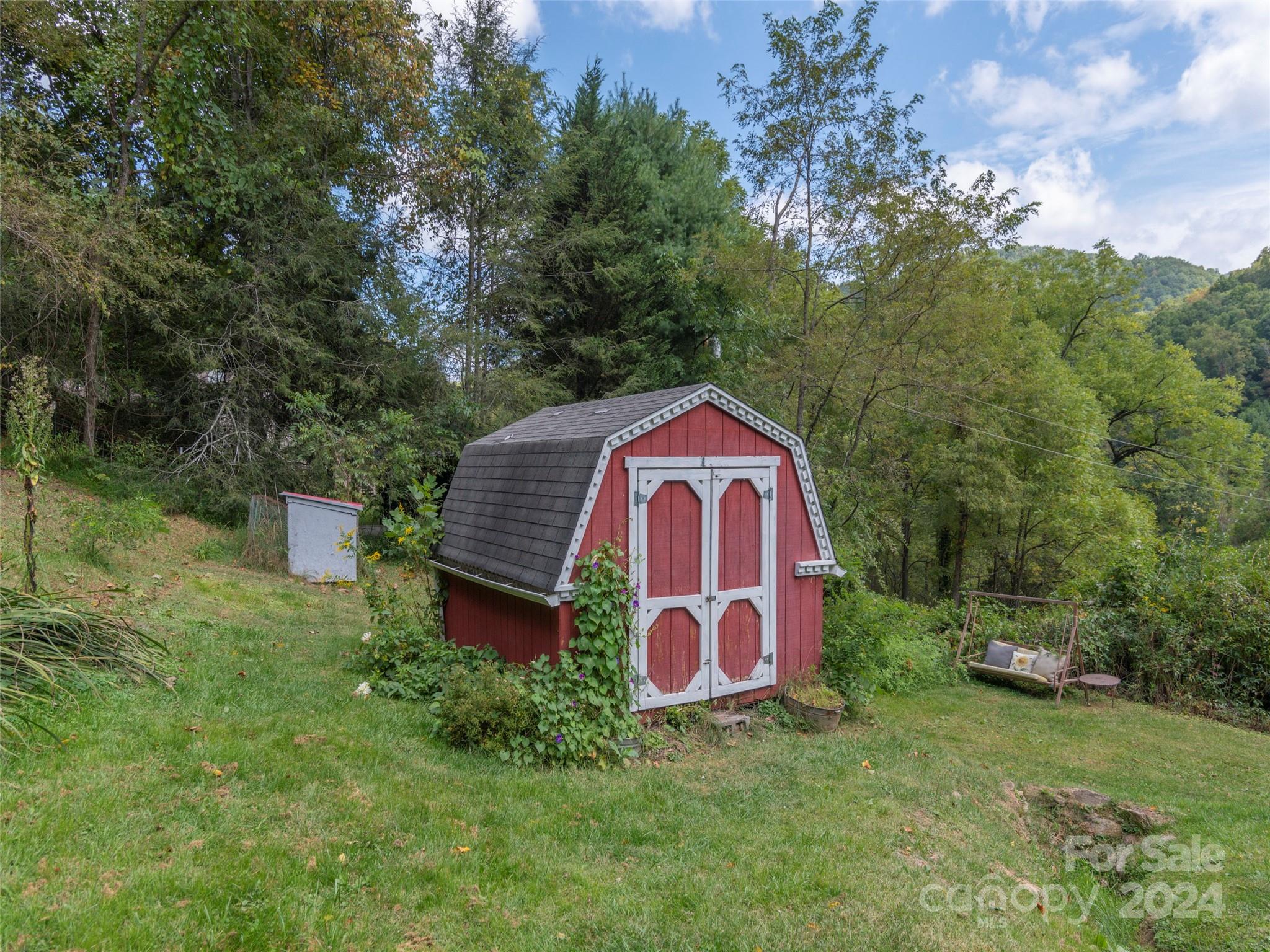 883 Price Town Road Clyde, NC 28721 - Photo 29 of 34 a view of a wooden house with a yard