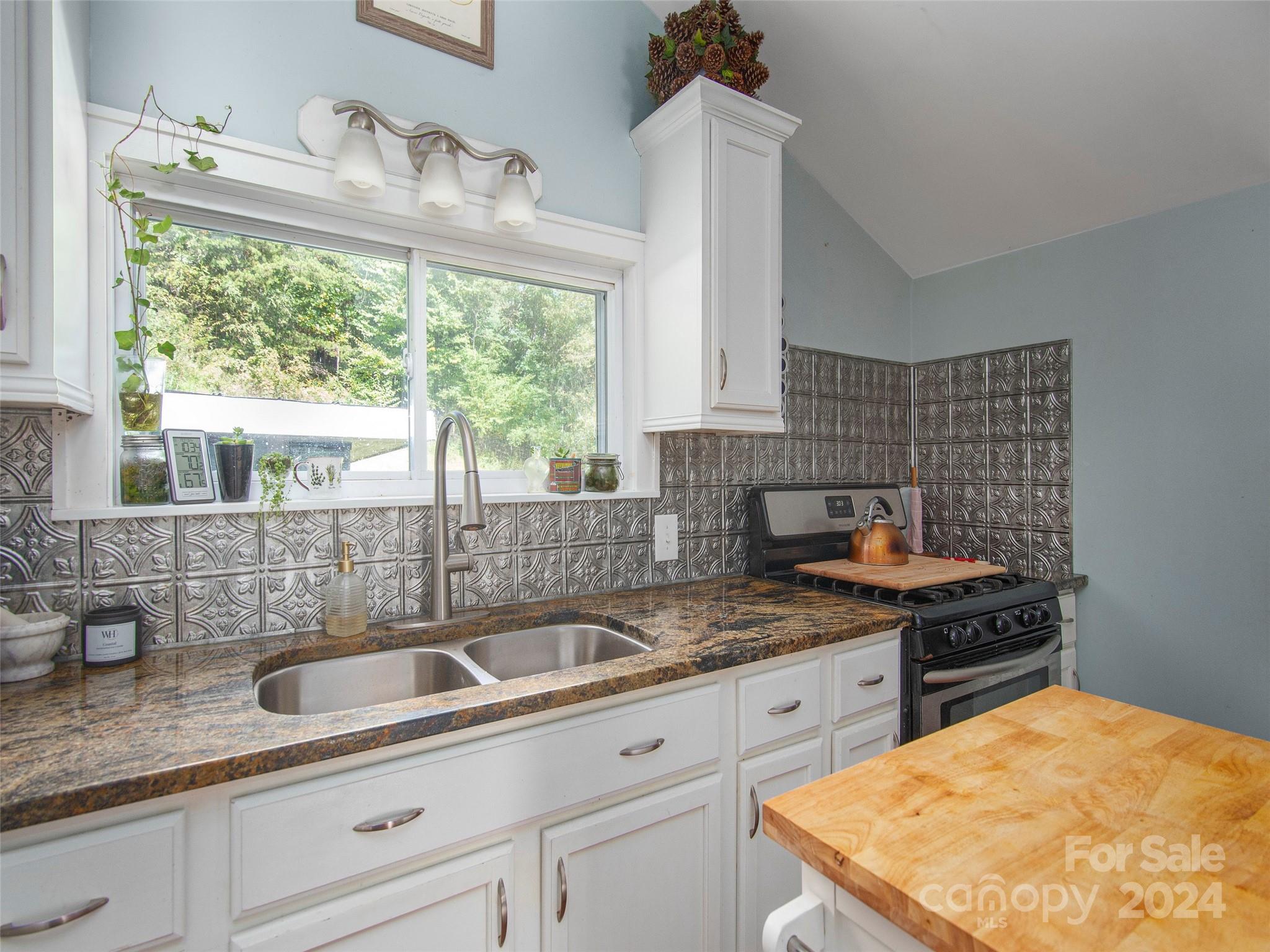 883 Price Town Road Clyde, NC 28721 - Photo 10 of 34 a kitchen with granite countertop a sink and a stove