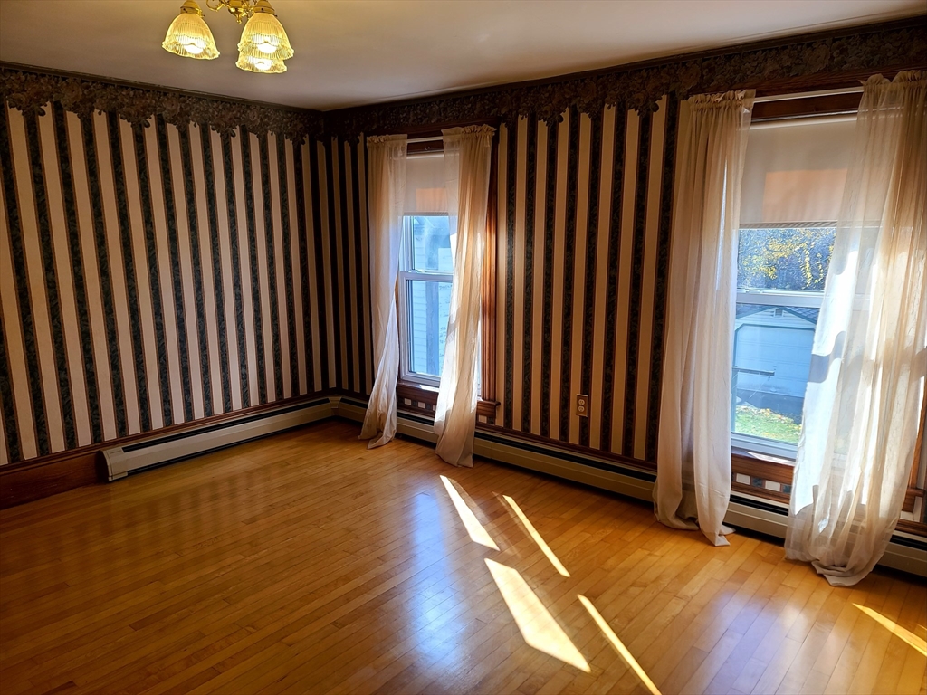 10 Maple Avenue Grafton, MA 01560 - Photo 4 of 9 an empty room with wooden floor and windows
