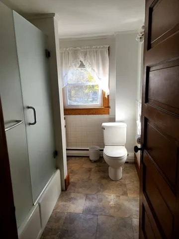 a bathroom with a toilet and a shower