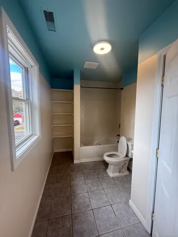 a bathroom with a toilet and a shower