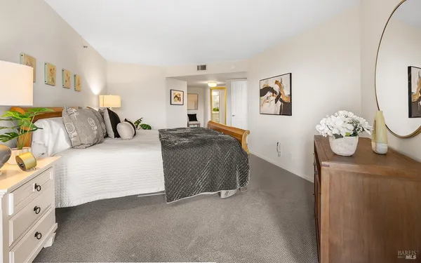 a bedroom with a bed and dresser with mirror