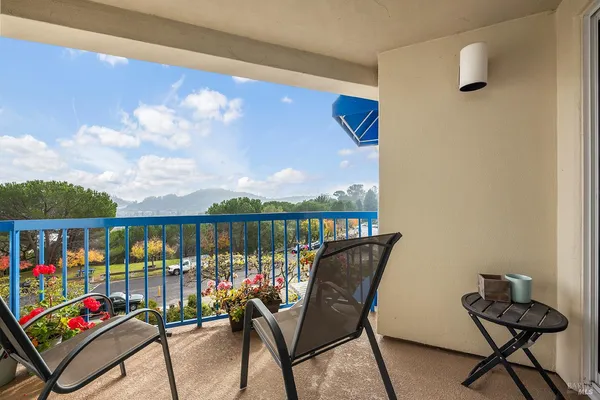 a balcony with outdoor seating and city view