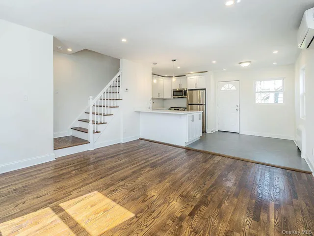 a view of a kitchen with wooden floor and electronic appliances