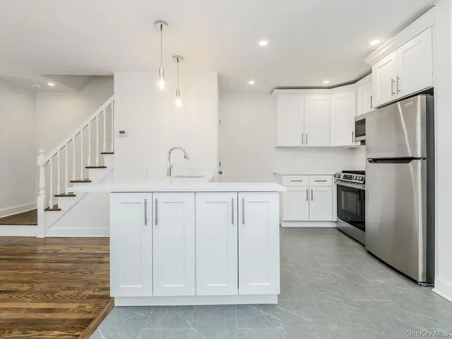 a kitchen with white cabinets and stainless steel appliances