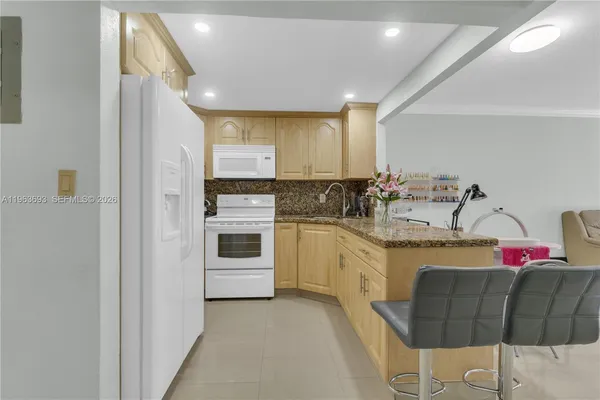 a kitchen with stainless steel appliances kitchen island granite countertop a sink and cabinets