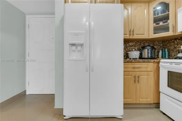 a kitchen with granite countertop white cabinets and white appliances