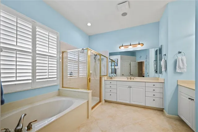 a spacious bathroom with sink mirror and bathtub