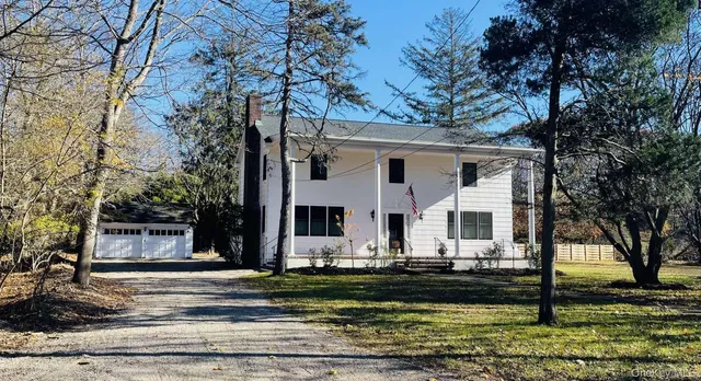 a front view of residential houses with yard and trees