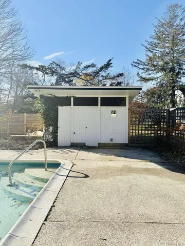 a view of a house with backyard and trees