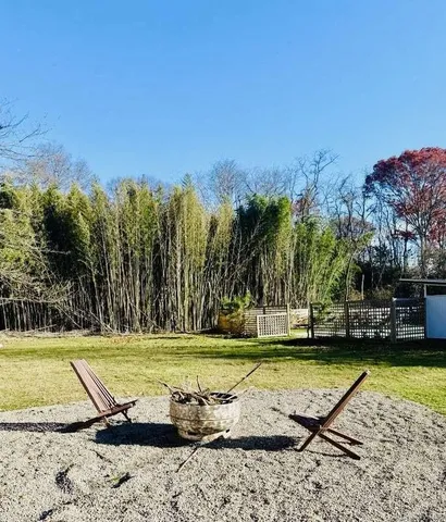 a front view of a house with a yard and a large tree