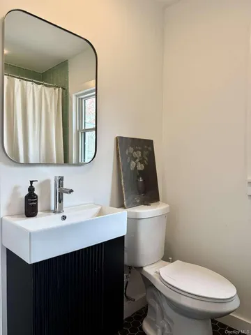 a bathroom with a sink vanity mirror and toilet