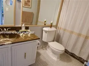 a bathroom with a granite countertop sink a toilet and a mirror