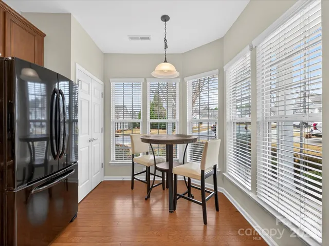 a dining room with furniture window wooden floor and a chandelier