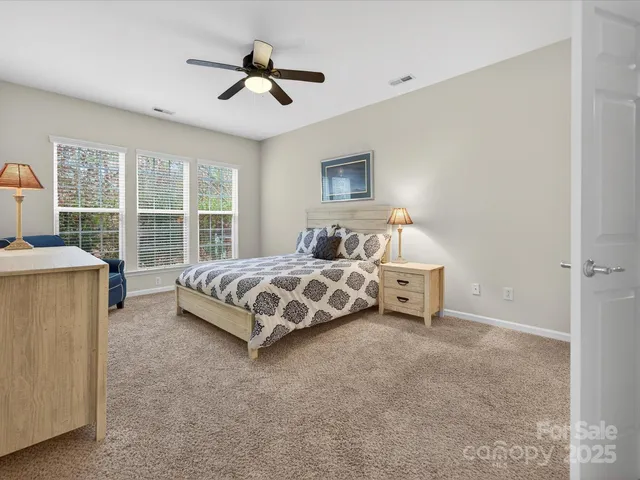 a bedroom with a bed a chandelier and a window