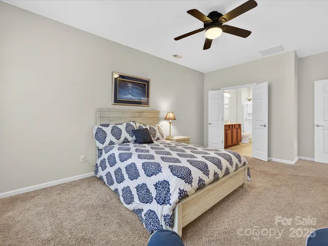 a bedroom with a bed and painting on the wall