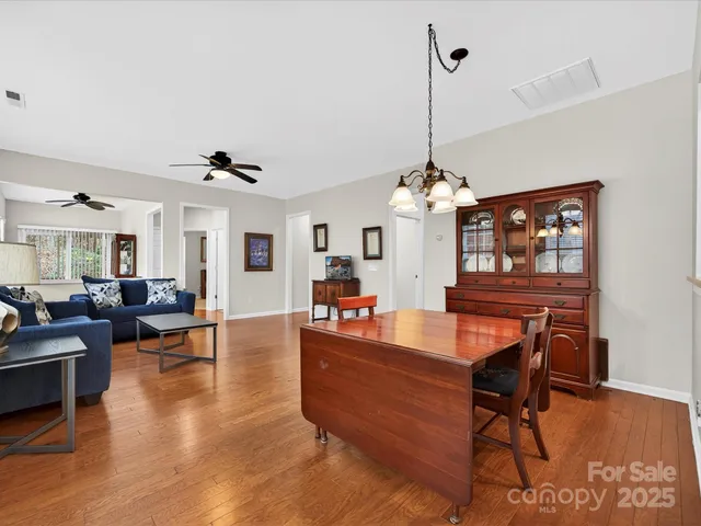 a dining room with furniture a chandelier and wooden floor