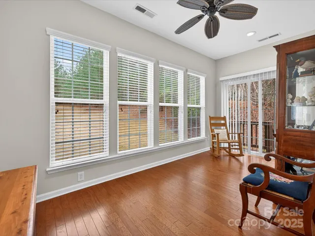 a view of a livingroom with furniture wooden floor and a large window