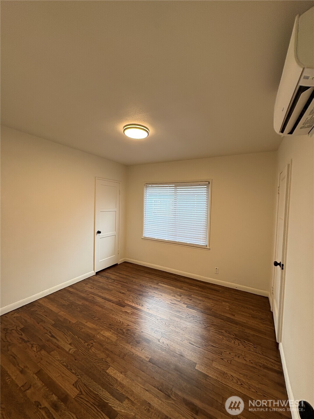 840 Northwest 54th Street Seattle, WA 98107 - Photo 4 of 18 an empty room with wooden floor and windows