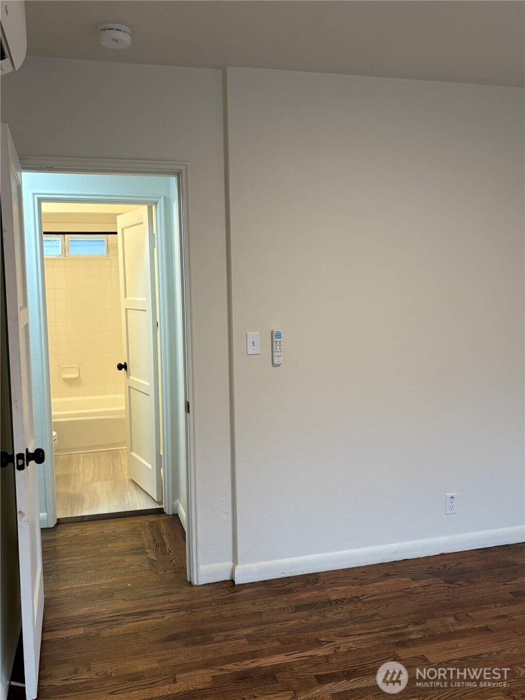 840 Northwest 54th Street Seattle, WA 98107 - Photo 6 of 18 a view of an empty room with wooden floor and a window