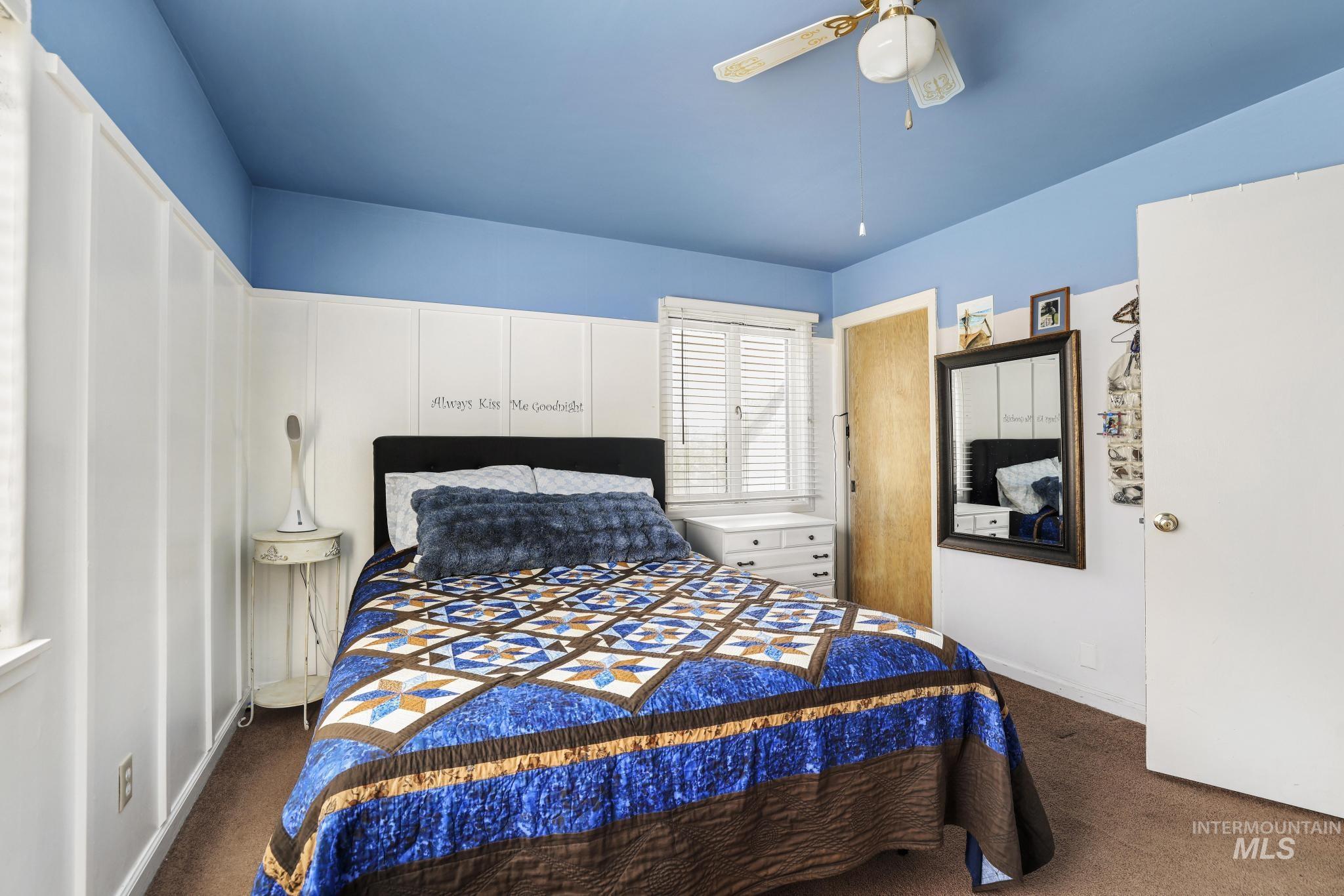 19591 Queen Crown Road Carey, ID 83320 - Photo 13 of 37 Bedroom featuring board and batten wainscoting, a light blue ceiling, and a ceiling fan with light fixture