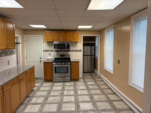 a kitchen with stainless steel appliances granite countertop a refrigerator and a stove top oven