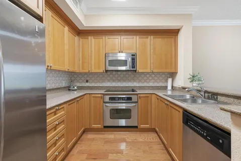 a kitchen with stainless steel appliances granite countertop a sink stove and cabinets